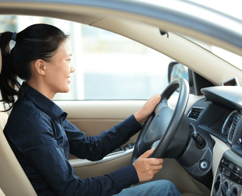 Young Asian woman driving car